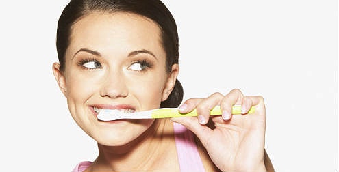Imagen de una mujer cepillándose los dientes
